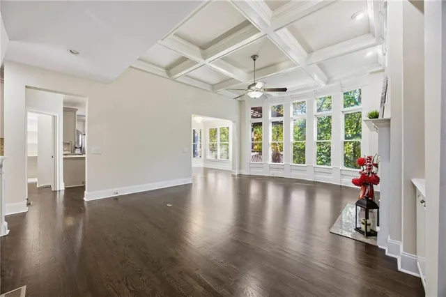 an empty room with a wooden floor and white walls