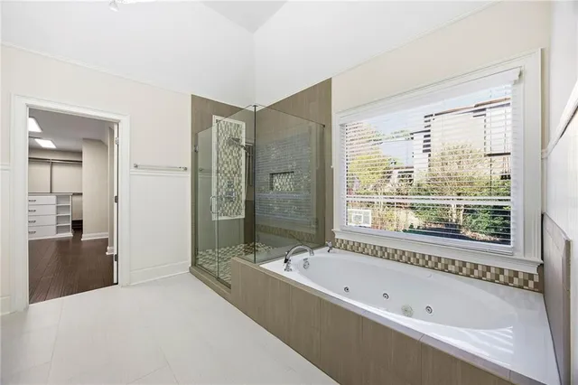 an empty room with wooden floor fireplace and windows