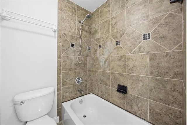 an empty room with wooden floor ceiling fan and windows