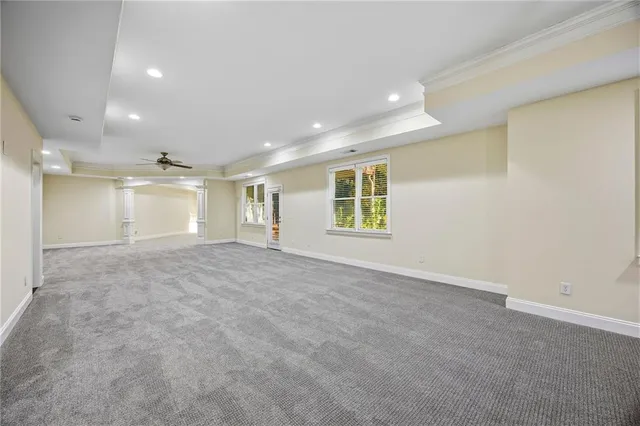 a view of a livingroom with a chandelier fan and windows