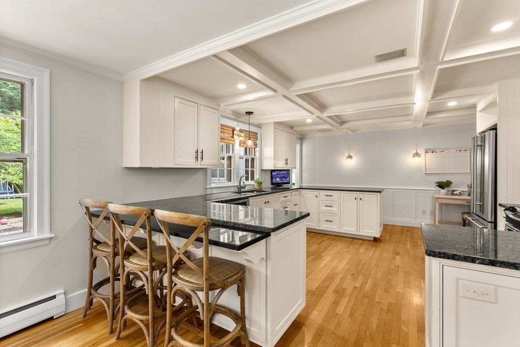 49 Sears Road Wayland, MA 01778 - Photo 6 of 30 a kitchen with a table chairs a sink dishwasher stove and cabinets with wooden floor