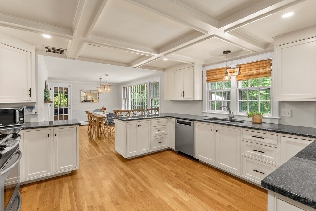 49 Sears Road Wayland, MA 01778 - Photo 9 of 30 a large white kitchen with wooden floors and white stainless steel appliances