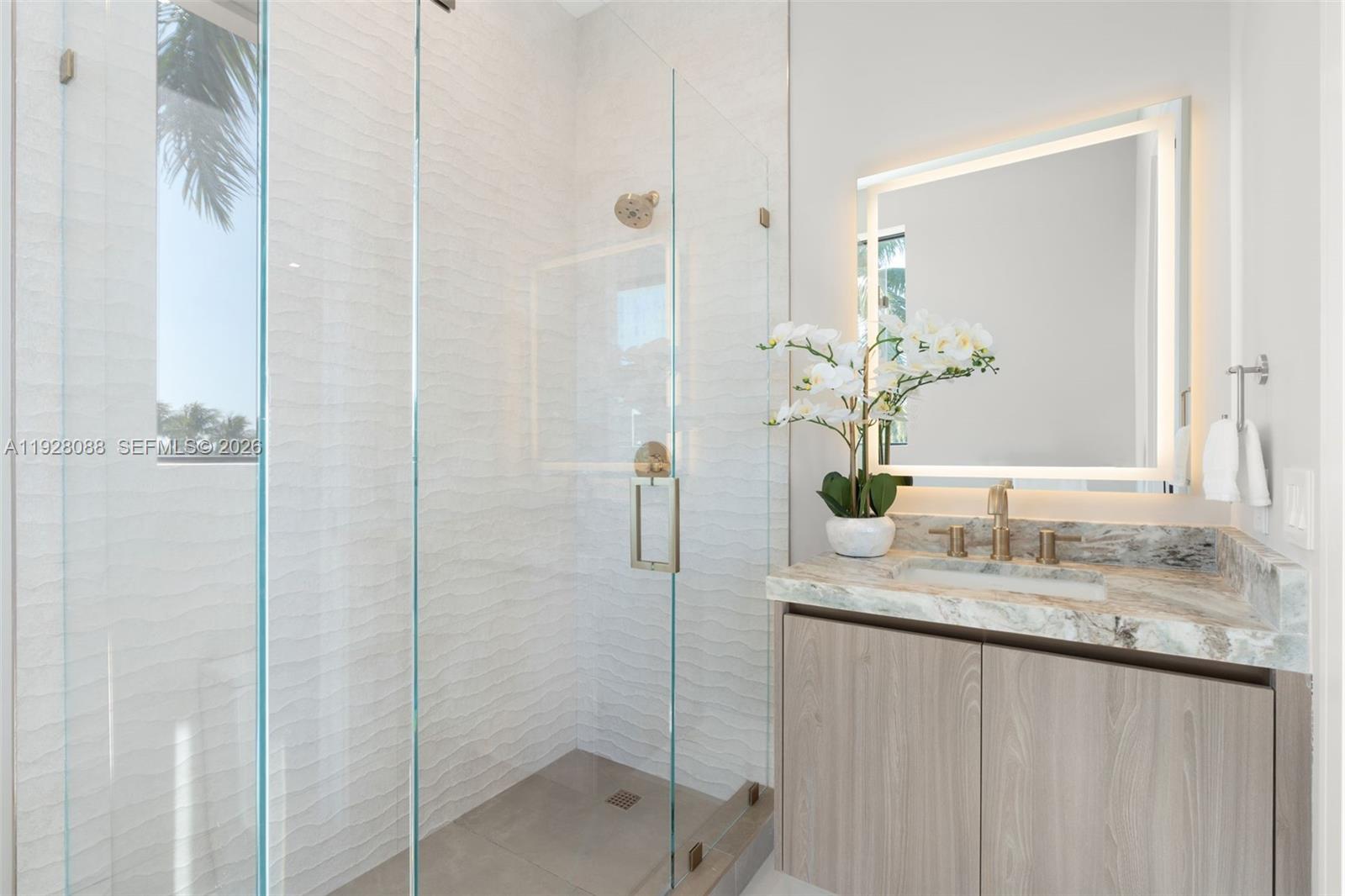 4910 Northeast 27th Avenue Lighthouse Point, FL 33064 - Photo 46 of 68 a bathroom with a granite countertop sink a mirror and a shower