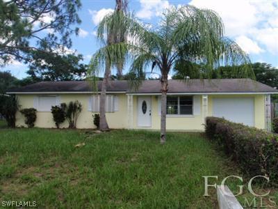 20 Colorado Road Lehigh Acres, FL 33936 - Photo 1 of 10 a front view of house with yard and lake view
