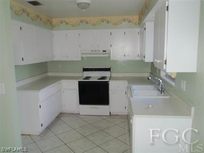 20 Colorado Road Lehigh Acres, FL 33936 - Photo 3 of 10 a kitchen with a sink stove and cabinets