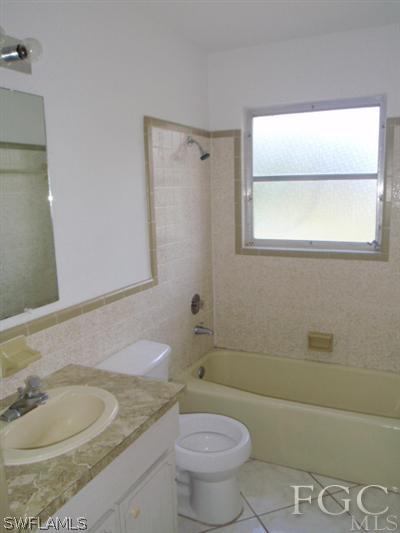20 Colorado Road Lehigh Acres, FL 33936 - Photo 6 of 10 a bathroom with a granite countertop toilet a sink and a bathtub