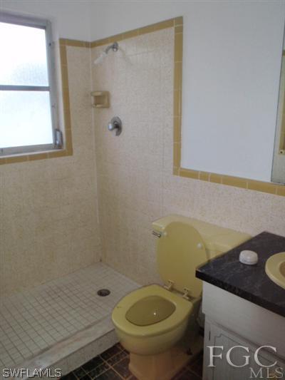 20 Colorado Road Lehigh Acres, FL 33936 - Photo 8 of 10 a bathroom with a granite countertop sink a toilet and shower