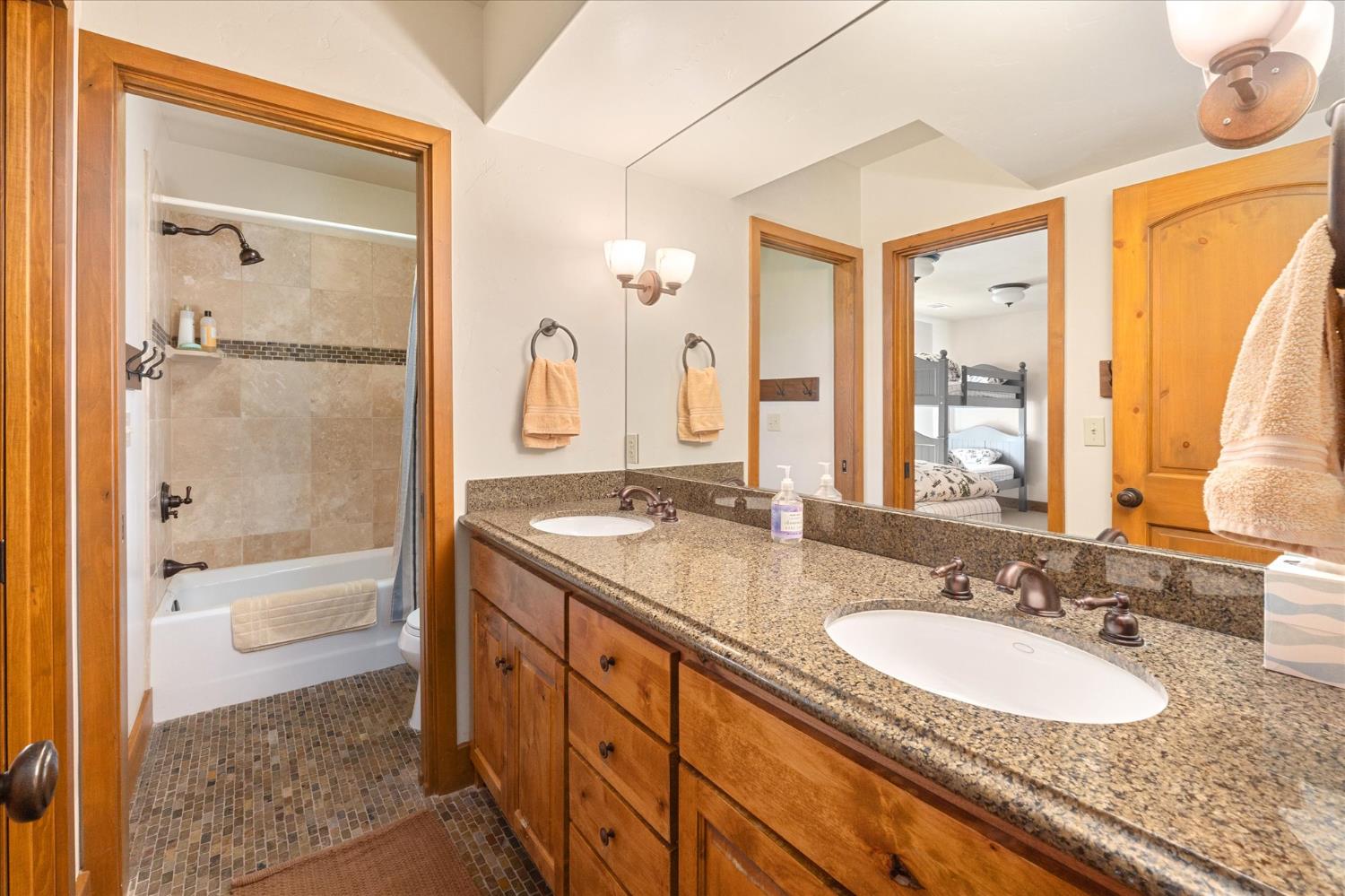 110 Flynn Road Bear Valley, CA 95223 - Photo 38 of 56 a bathroom with a granite countertop sink mirror bathtub and next to a window