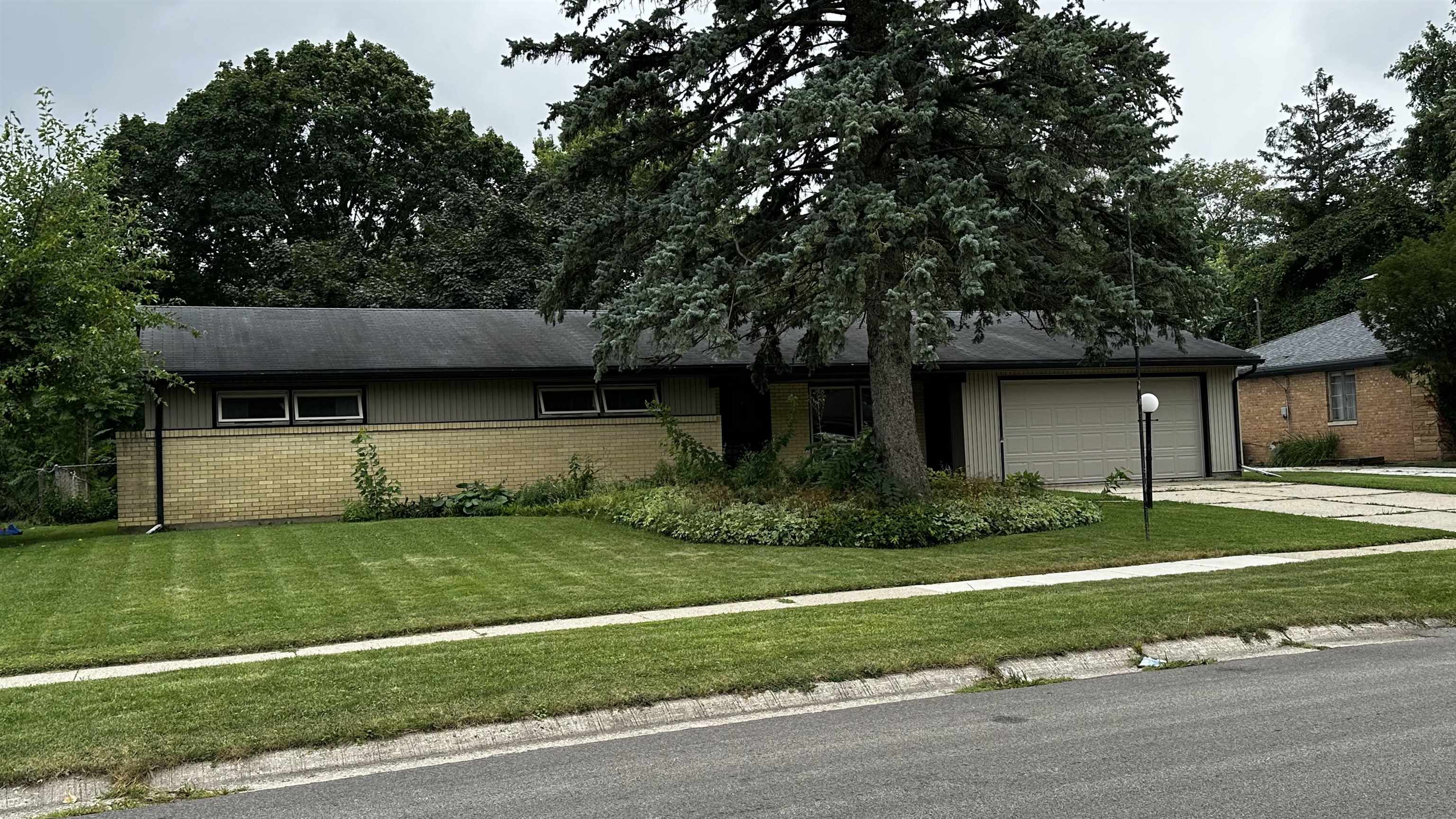 4721 Highcrest Road Rockford, IL 61107 - Photo 1 of 22 a view of a backyard with plants and large tree