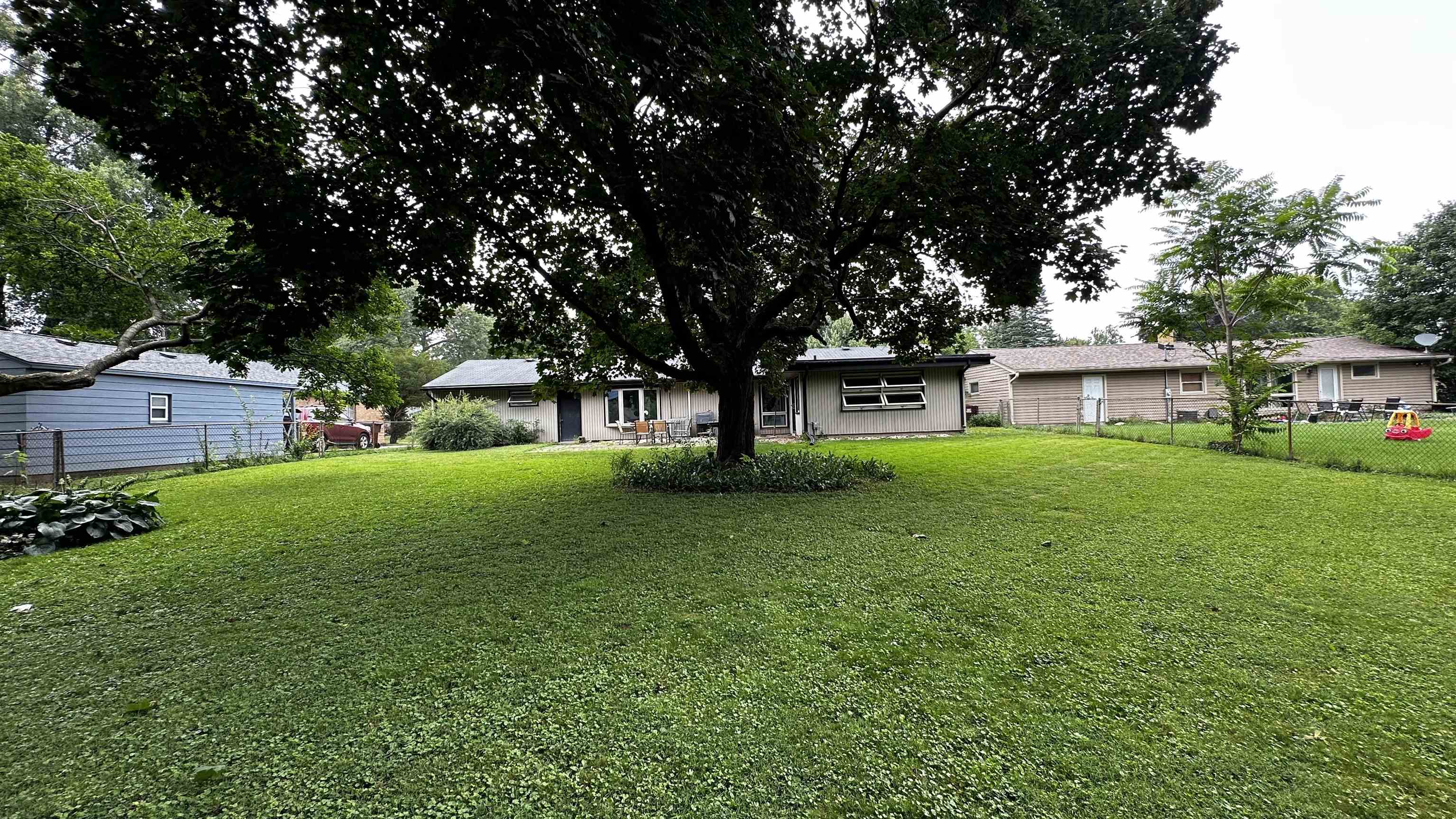 4721 Highcrest Road Rockford, IL 61107 - Photo 21 of 22 a view of house in front of a big yard with large trees
