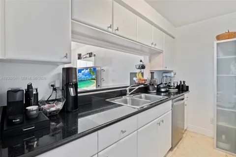 a kitchen with sink and white cabinets