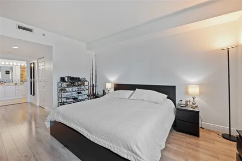 a spacious bedroom with a bed and a wooden floor