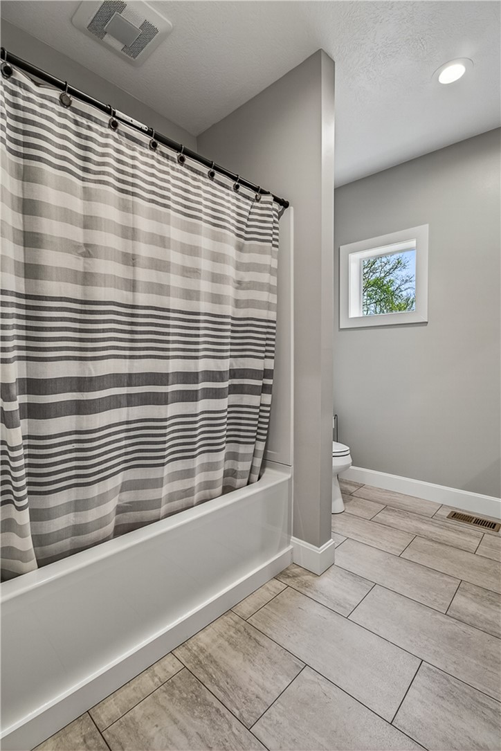 8700 Quaker Trace Road Camden, OH 45311 - Photo 12 of 34 This bathroom features elegant tile flooring and a functional bathtub, creating a serene and practical space.