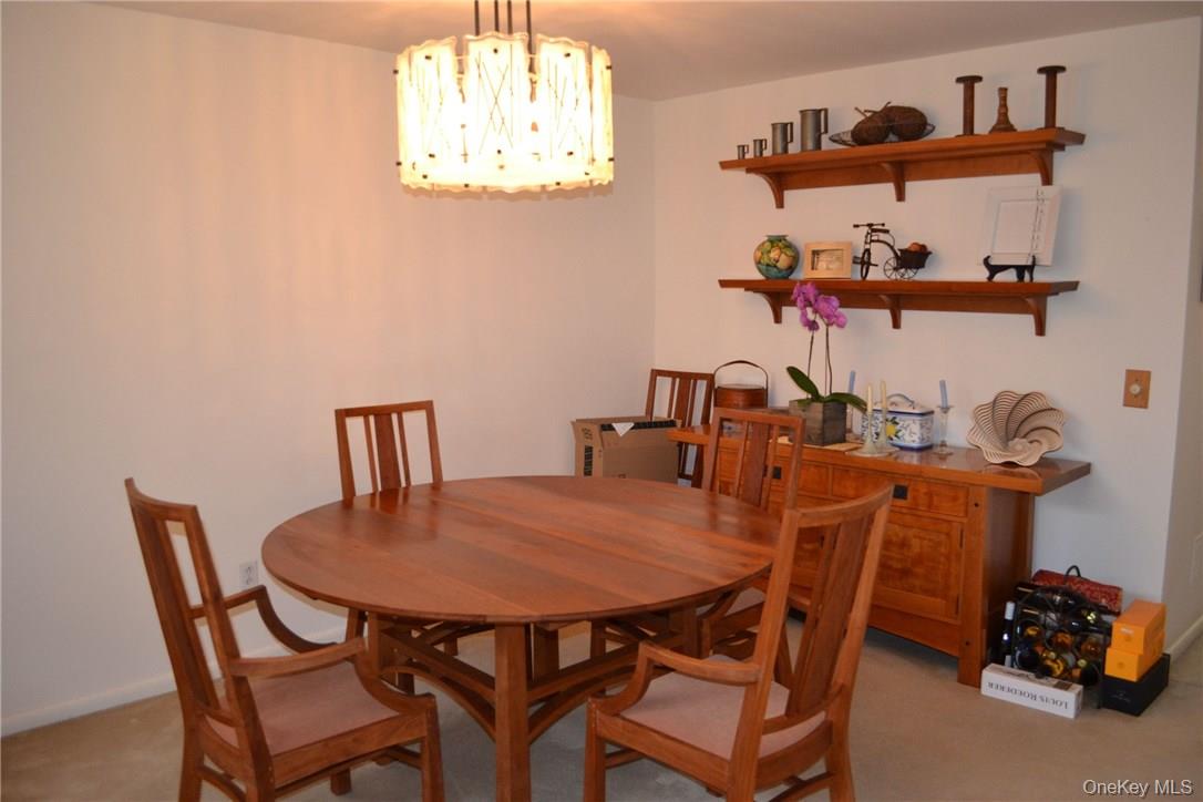 150 North Bedford Road, Unit 2F Chappaqua, NY 10514 - Photo 3 of 13 a view of a dining room with furniture and chandelier
