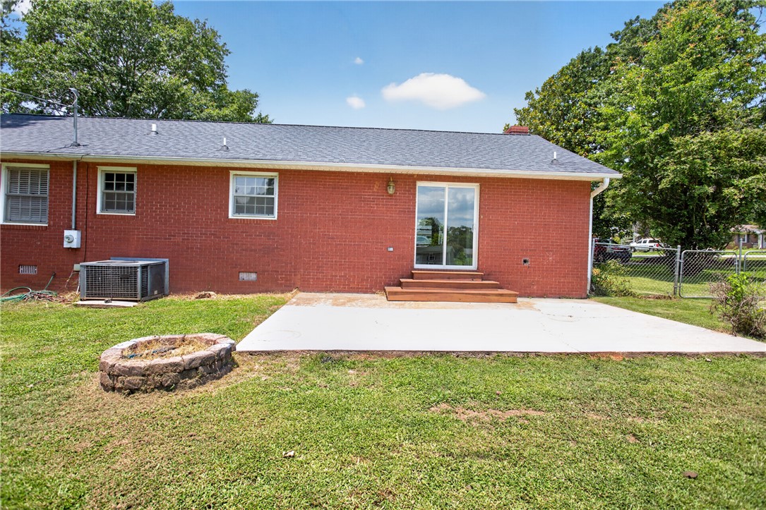 113 Greenfield Avenue Pendleton, SC 29670 - Photo 26 of 40 A spacious backyard patio, perfect for evening gatherings, features a fire pit and direct access to the home.