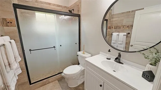 a bathroom with a sink mirror toilet and shower