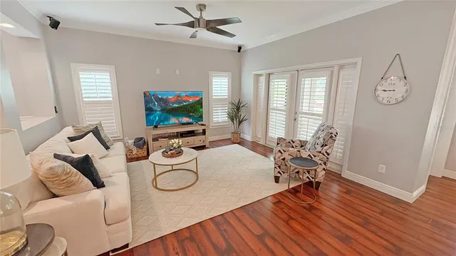 a living room with furniture a flat screen tv and a window