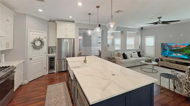 a large kitchen with stainless steel appliances kitchen island granite countertop a refrigerator and a stove top oven