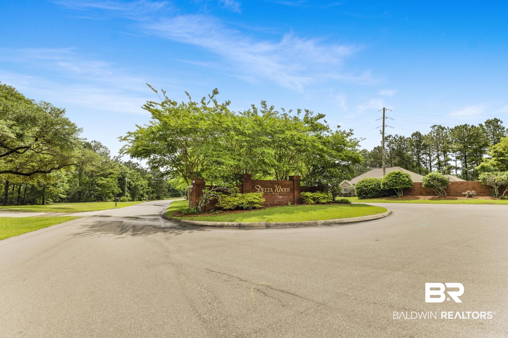 35814 Delvan Lane Bay Minette, AL 36507 - Photo 52 of 53 Community entrance featuring a brick monument sign, mature trees, and established landscaping