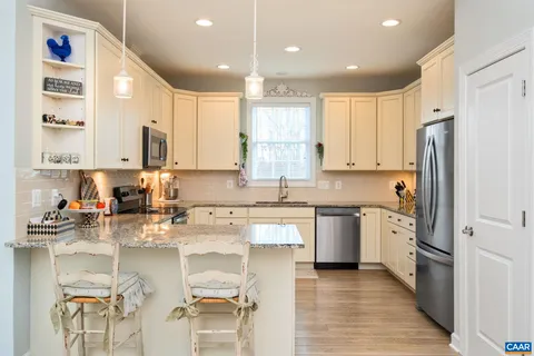 a kitchen with granite countertop white cabinets and a window