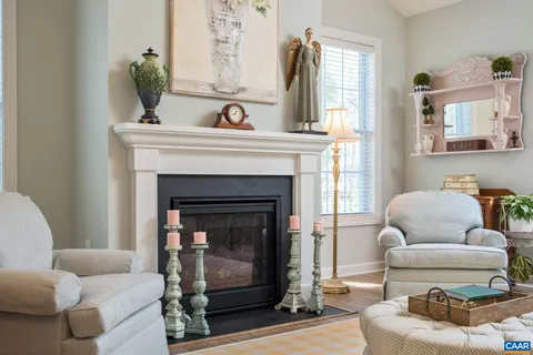 a kitchen with stainless steel appliances granite countertop a stove top oven a sink dishwasher and white cabinets with wooden floor