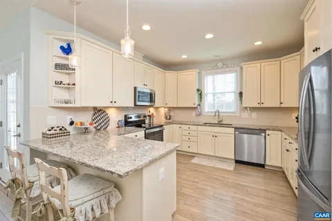 a kitchen with stainless steel appliances granite countertop a refrigerator and a stove top oven