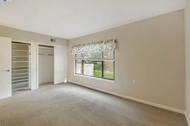 an empty room with windows and closet