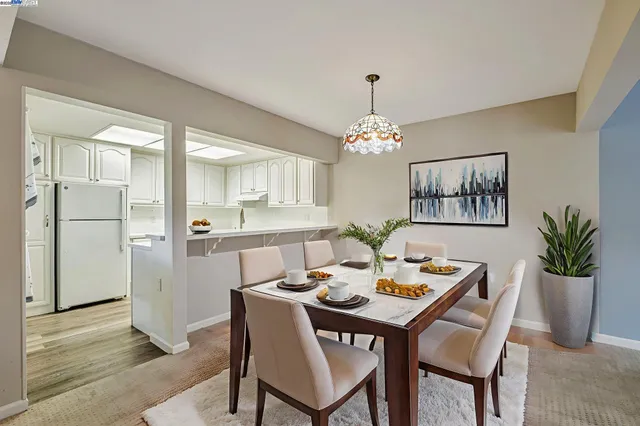 a dining room with furniture a chandelier and wooden floor