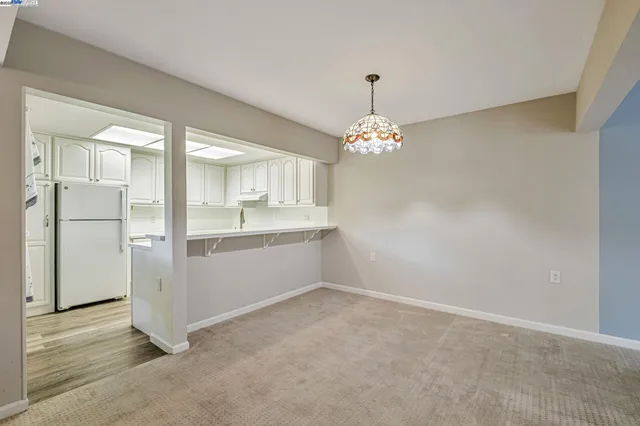 a view of a kitchen with refrigerator and chandelier