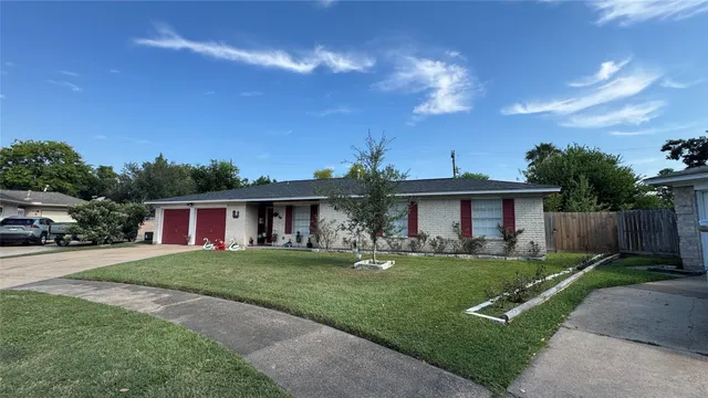 a front view of a house with a yard and trees