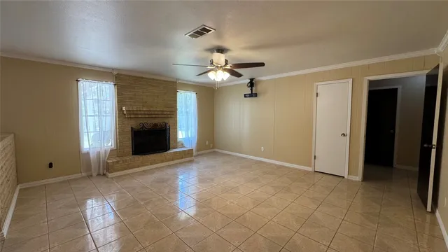 an empty room with windows and fireplace