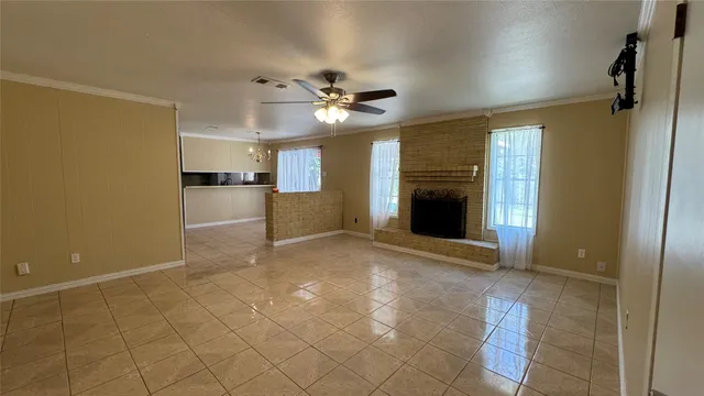 a view of a livingroom with a chandelier fan and windows