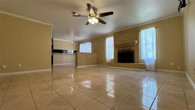 a view of a livingroom with a fireplace and a ceiling fan