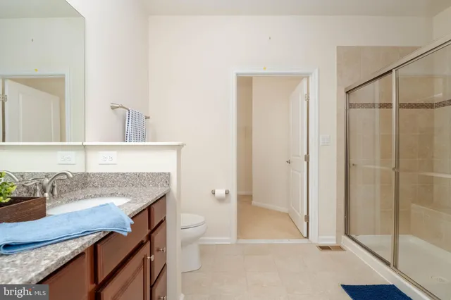 a bathroom with a granite countertop sink a toilet and shower