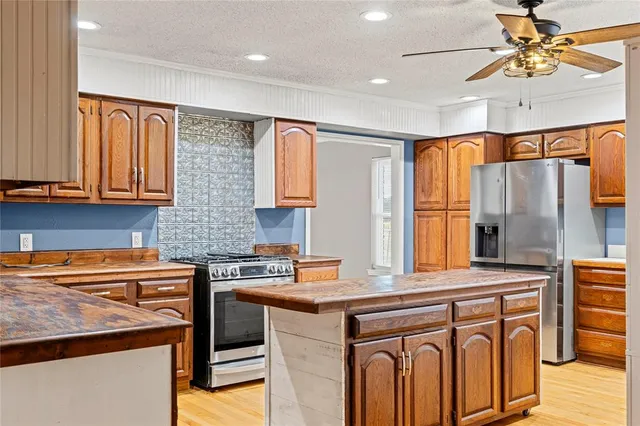 a kitchen with stainless steel appliances granite countertop a sink stove and refrigerator