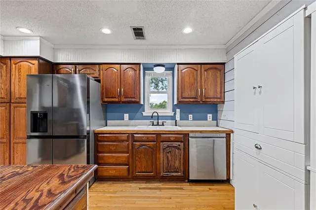 a kitchen with stainless steel appliances granite countertop a refrigerator and a sink