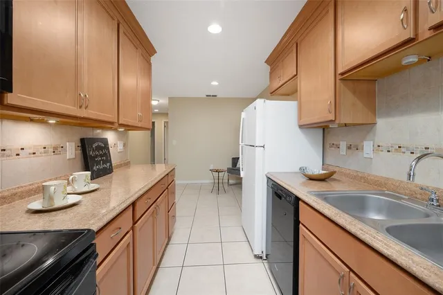 a kitchen with a sink dishwasher and cabinets