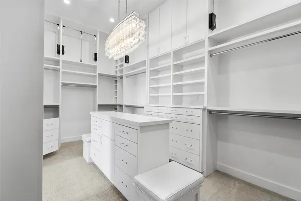 a kitchen with white cabinets and window