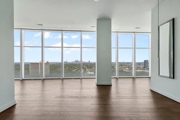 a view of a room with wooden floor and a floor to ceiling window