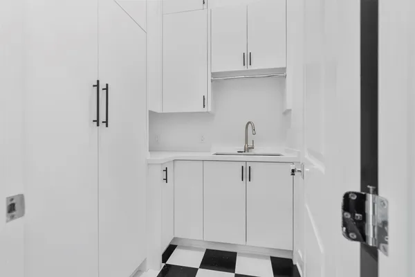 a kitchen with white cabinets and white appliances