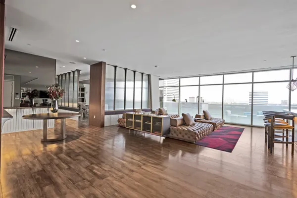 a living room with furniture and floor to ceiling windows
