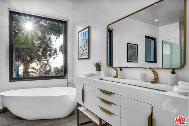 a bathroom with a tub a sink and mirror