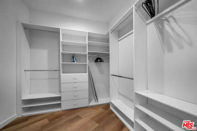 a view of walk in closet with empty racks