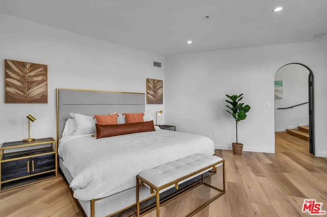 a bedroom with a bed and a potted plant