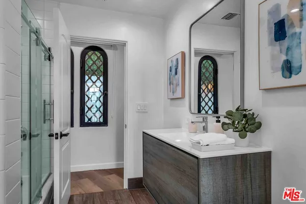 a bathroom with windows a sink and a mirror