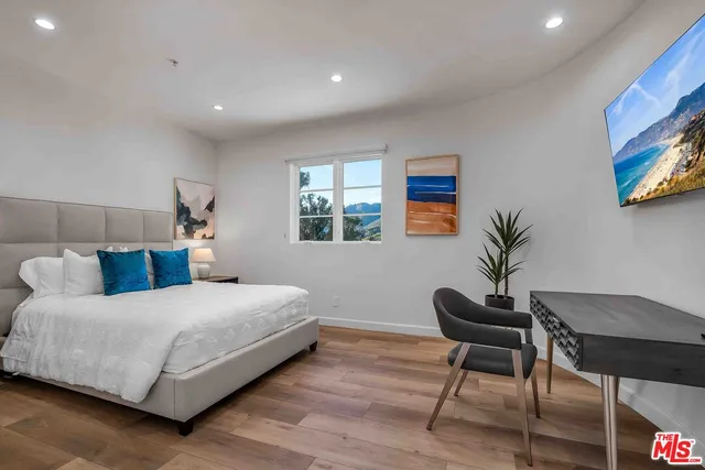 a bedroom with a large bed and a desk