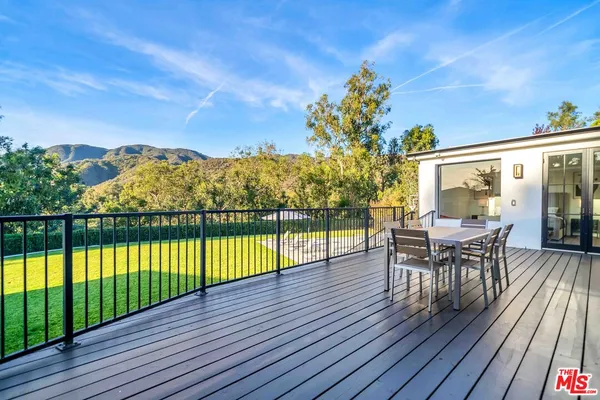a view of a chairs and table on the wooden deck