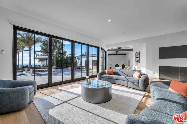 a living room with fireplace furniture and a large window