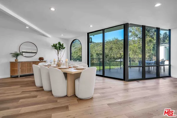 a living room with large windows and wooden floor