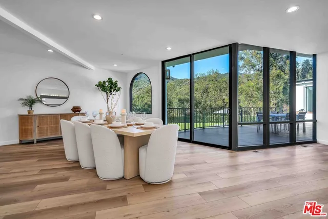 a living room with large windows and wooden floor